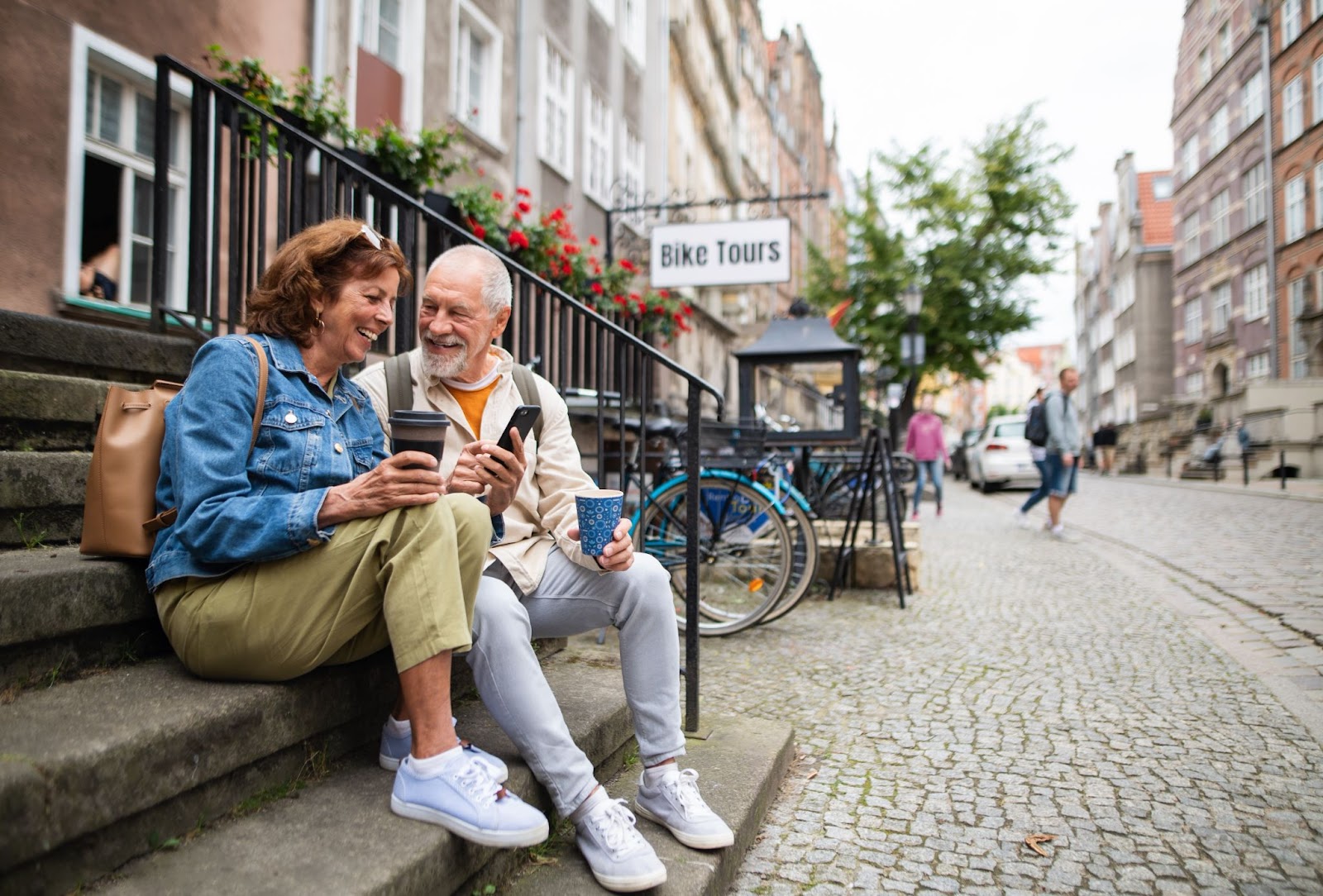 A happy senior couple laughing together as they wait to go on a bike tour.